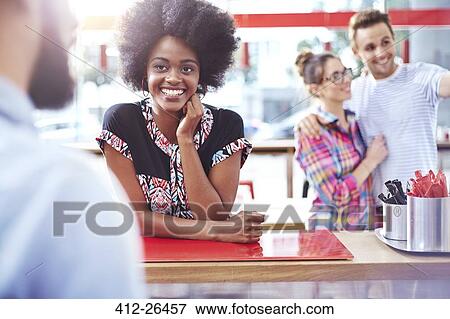 Smiling woman at counter in cafe View Large Photo Image Stock Photo - Smiling woman at counter in cafe. Fotosearch