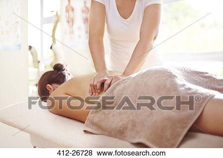 Stock Photo - Woman receiving massage by masseuse. Fotosearch