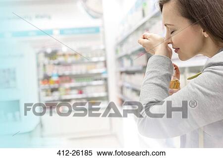 Woman trying on perfume in pharmacy View Large Photo Image Stock Photography - Woman trying on perfume in pharmacy. Fotosearch