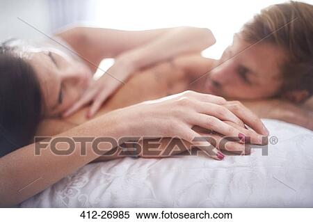 Affectionate couple holding hands laying on bed View Large Photo Image Stock Photography - Affectionate couple holding hands laying on bed. Fotosearch