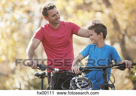 Affectionate father and son with mountain bikes outdoors View Large Photo Image Stock Image - Affectionate father and son with mountain bikes outdoors. Fotosearch
