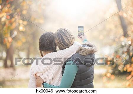 Affectionate mother and daughter taking selfie outdoors View Large Photo Image Stock Photograph - Affectionate mother and daughter taking selfie outdoors. Fotosearch