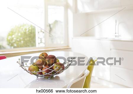 Apples in wire basket on modern kitchen table View Large Photo Image Stock Photograph - Apples in wire basket on modern kitchen table. Fotosearch