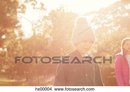 Boy and girl walking among sunny trees View Large Photo Image Picture - Boy and girl walking among sunny trees. Fotosearch