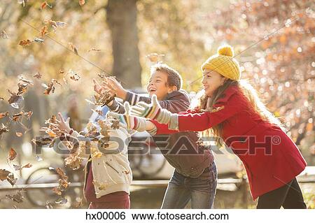 Stock Photograph - Boys and girl catching autumn leaves. Fotosearch