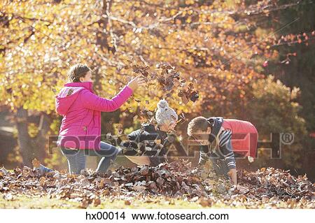 Picture - Boys and girl playing in autumn leaves. Fotosearch