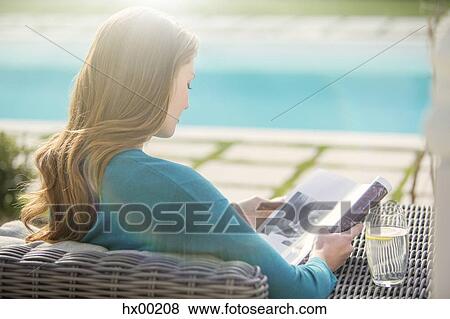 Brunette woman reading magazine at luxury poolside View Large Photo Image Stock Photo - Brunette woman reading magazine at luxury poolside. Fotosearch