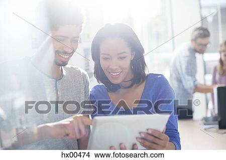 Picture - Business people using digital tablet in sunny office. Fotosearch