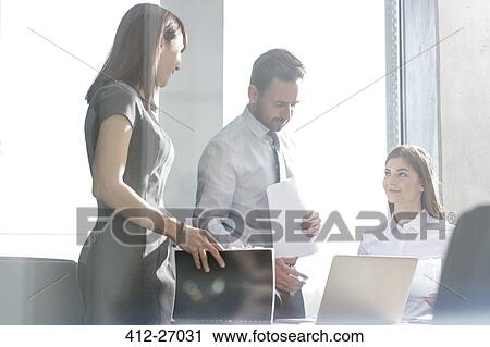 Stock Image - Business people working at laptop in conference room meeting. Fotosearch