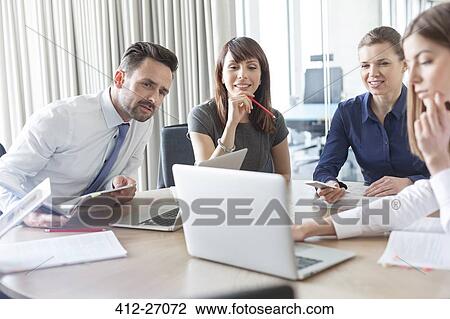 Business people working at laptop in conference room View Large Photo Image Stock Image - Business people working at laptop in conference room. Fotosearch
