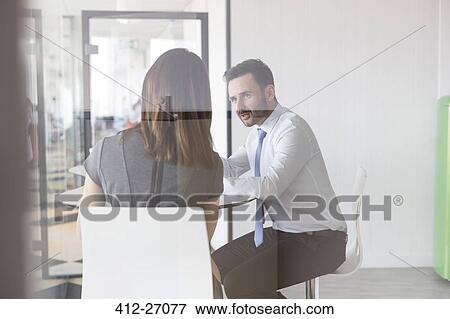 Businessman and businesswoman talking in office View Large Photo Image Stock Photo - Businessman and businesswoman talking in office. Fotosearch