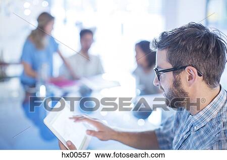 Stock Photo - Businessman using digital tablet in office. Fotosearch