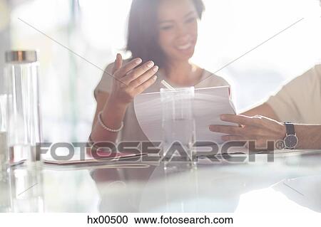 Businesswoman gesturing to paperwork in meeting View Large Photo Image Stock Image - Businesswoman gesturing to paperwork in meeting. Fotosearch