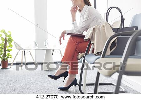 Businesswoman waiting with legs crossed in lobby View Large Photo Image Stock Image - Businesswoman waiting with legs crossed in lobby. Fotosearch