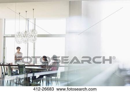 Stock Image - Businesswomen talking in conference room. Fotosearch