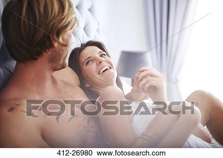 Casual couple cuddling on bed View Large Photo Image Stock Image - Casual couple cuddling on bed. Fotosearch