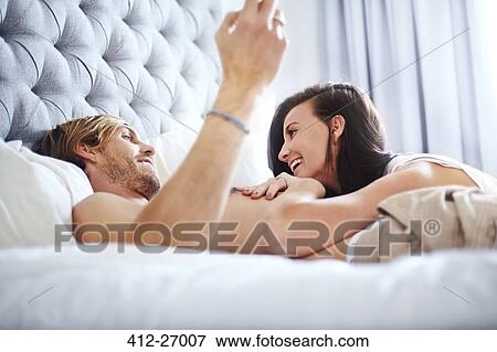 Stock Photo - Casual couple laying on bed. Fotosearch