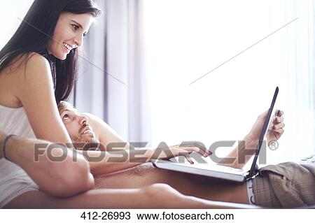 Casual couple laying with laptop View Large Photo Image Stock Image - Casual couple laying with laptop. Fotosearch
