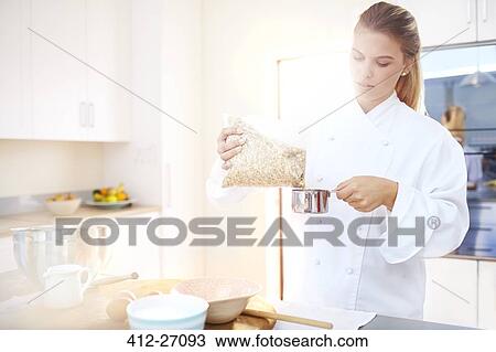 Stock Image - Chef measuring ingredient in kitchen. Fotosearch