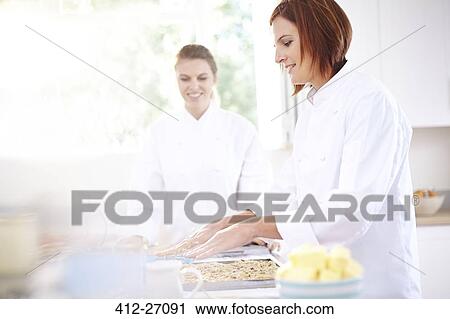 Stock Image - Chefs baking in kitchen. Fotosearch