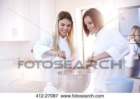 Chefs baking in sunny kitchen View Large Photo Image Stock Photo - Chefs baking in sunny kitchen. Fotosearch
