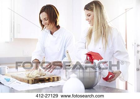 Stock Photo - Chefs baking kneading dough on cutting board in kitchen. Fotosearch