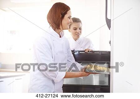 Chefs placing tray in oven View Large Photo Image Picture - Chefs placing tray in oven. Fotosearch