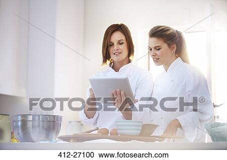 Chefs using digital tablet in kitchen View Large Photo Image Stock Image - Chefs using digital tablet in kitchen. Fotosearch