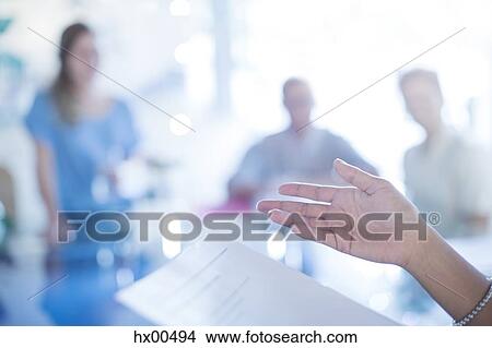 Picture - Close up of businesswoman’s hand gesturing to paperwork in meeting. Fotosearch