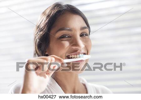 Stock Photo - Close up portrait smiling woman brushing teeth. Fotosearch