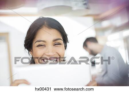 Stock Image - Close up portrait smiling woman using digital tablet. Fotosearch