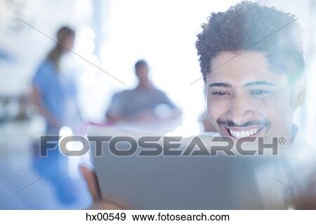 Close up smiling businessman using digital tablet View Large Photo Image Stock Photo - Close up smiling businessman using digital tablet. Fotosearch