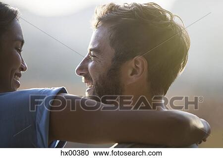 Stock Image - Close up smiling couple hugging. Fotosearch