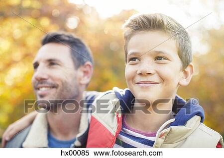 Close up smiling father and son hugging outdoors View Large Photo Image Stock Photography - Close up smiling father and son hugging outdoors. Fotosearch