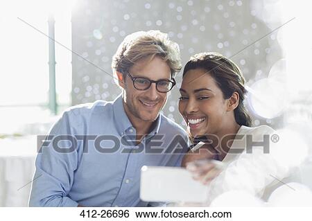 Stock Photograph - Couple taking selfie with camera phone. Fotosearch