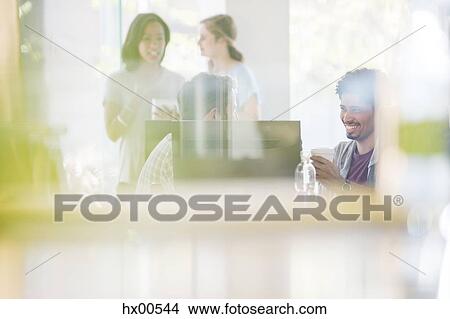 Picture - Creative business people drinking coffee and talking office. Fotosearch