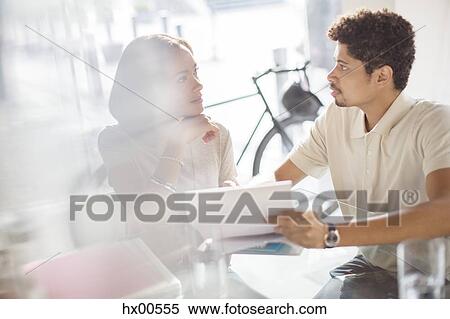 Stock Photography - Creative business people reviewing paperwork in office. Fotosearch
