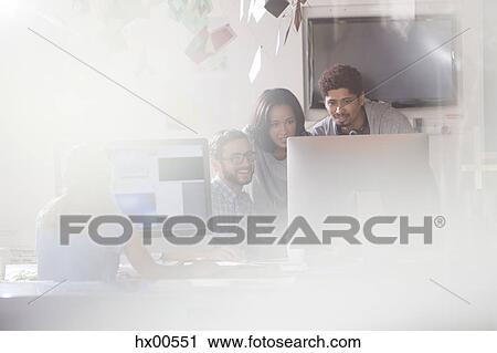 Stock Image - Creative business people using computer in office. Fotosearch