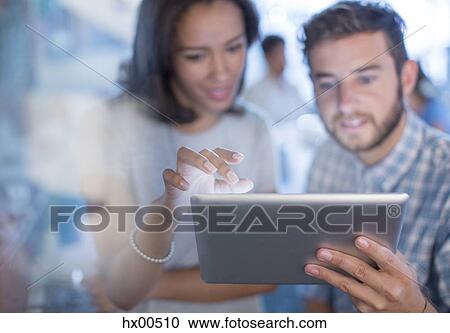 Stock Image - Creative business people using digital tablet in office. Fotosearch