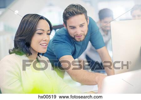 Creative business people using laptop in office View Large Photo Image Stock Photo - Creative business people using laptop in office. Fotosearch