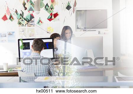Stock Image - Creative business people working at computers in office. Fotosearch