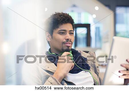 Picture - Creative businessman with headphones using digital tablet. Fotosearch