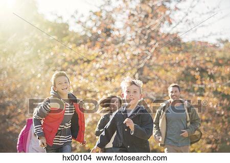 Energetic family running in autumn park View Large Photo Image Picture - Energetic family running in autumn park. Fotosearch