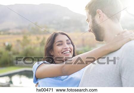 Stock Image - Enthusiastic couple hugging outdoors. Fotosearch