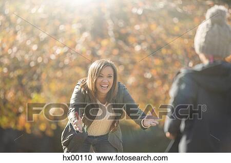 Enthusiastic mother reaching for son in autumn park View Large Photo Image Stock Image - Enthusiastic mother reaching for son in autumn park. Fotosearch