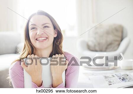 Stock Photography - Enthusiastic woman hugging digital tablet. Fotosearch