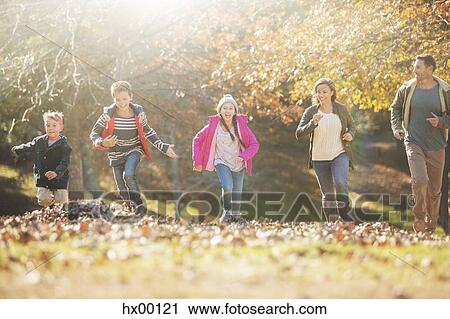 Family running in park with autumn leaves View Large Photo Image Stock Image - Family running in park with autumn leaves. Fotosearch