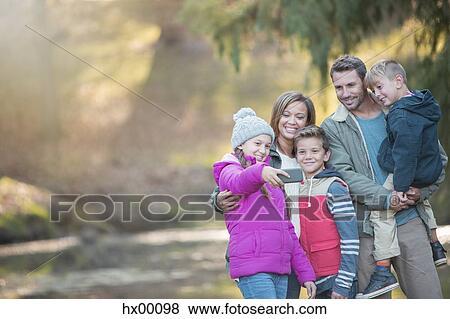 Family taking selfie with camera phone in woods View Large Photo Image Stock Photo - Family taking selfie with camera phone in woods. Fotosearch