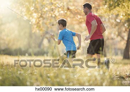 Father and son jogging in park View Large Photo Image Stock Image - Father and son jogging in park. Fotosearch