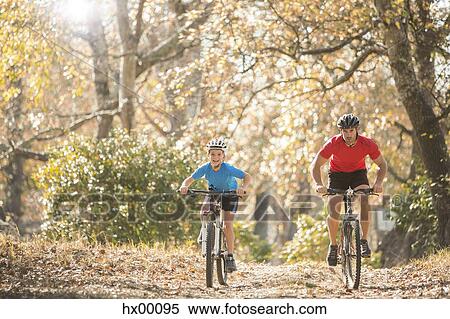 Father and son mountain biking on path in woods View Large Photo Image Stock Photography - Father and son mountain biking on path in woods. Fotosearch